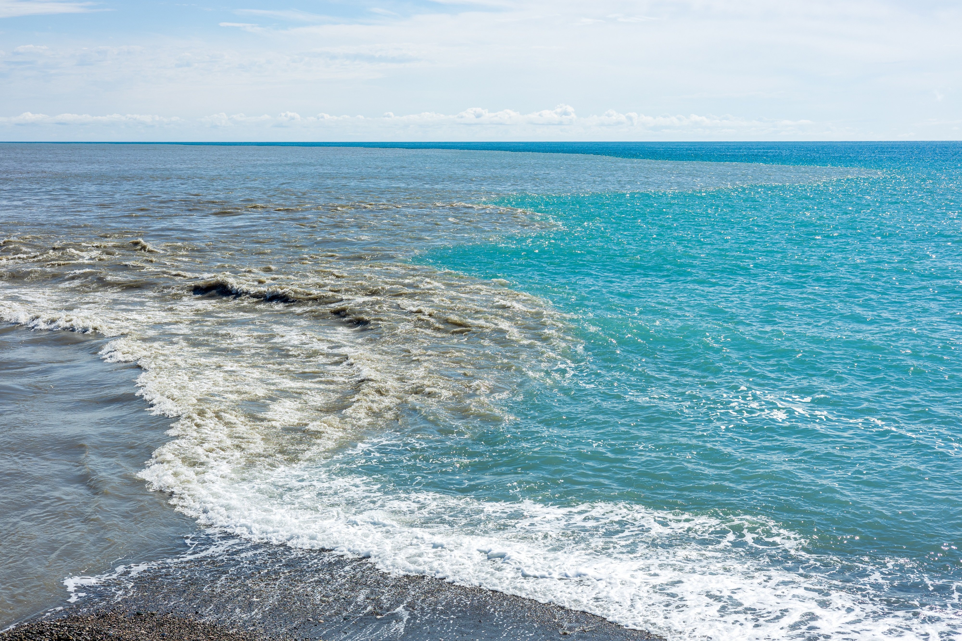 Sewage runoff flowing into clean sea water