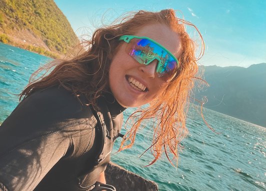 Sarah Jackson smiles in a wetsuit on a lake.