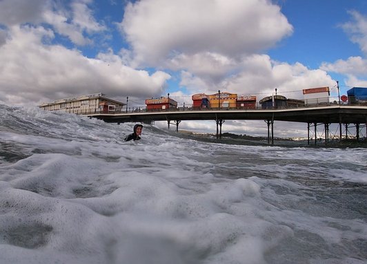 A fundraiser swimming for Marine Consevation Society. A pier can be seen behind her.