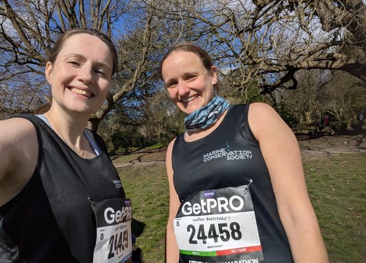 2 Bath half fundraisers smiling at the camera. They are wearing Marine Conservation Society branded clothes