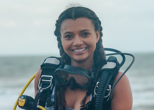 Inka Cresswell smiles at the camera wearing a diving buoyancy floatation device (BCD).