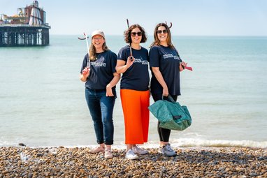 Marine Conservation Society's partnerships team posing together on a pebble beach