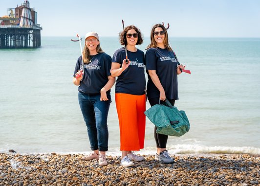 Marine Conservation Society's partnerships team posing together on a pebble beach