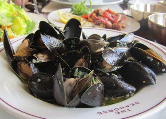 A bowl of mussels takes centre stage, surrounded by other seafood dishes