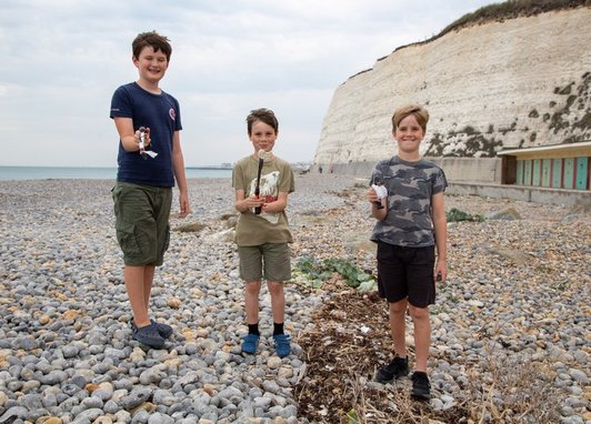 Great British Beach Clean event on a stony beach in Seaford, Sussex.