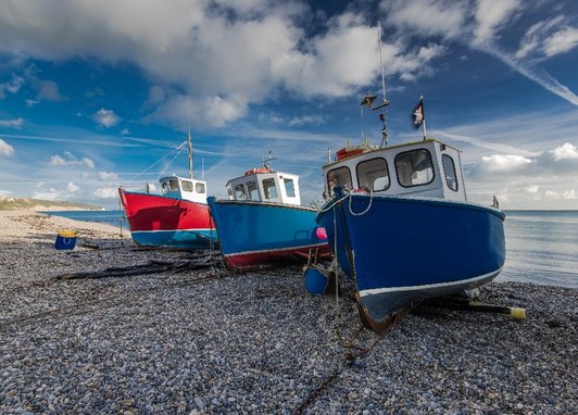 Boats resting on the beach of Beer, a small coastal village in Devon, England.