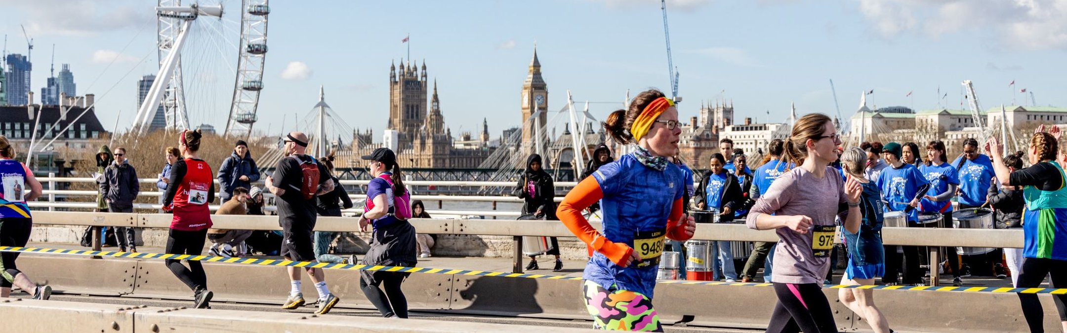Runners are photographed taking part in a half marathon. The London Eye can be seen in the background.
