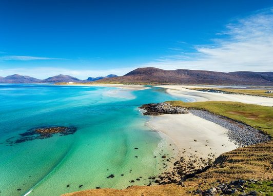Seilebost beach on the Isle of Harris in the Outer Hebrides of Scotland - a sandy coast with a striking blue sea. The image is captured from an outcrop above the beach.